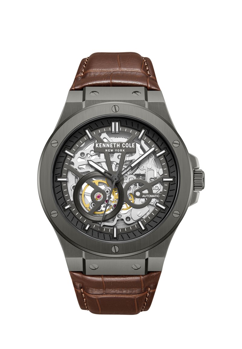 Automātiskās pulksteņi ar melnu skeleta ciparnīcu, sudraba toņa mehānismu, pelēku korpusu un brūnu krokodila raksta ādas siksnu.