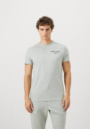 Sivá bavlnená tričko s krátkymi rukávmi a okrúhlym výstrihom. Má čierne branding "BJÖRN BORG" na ľavej strane hrude. Mierne priliehajúci strih.