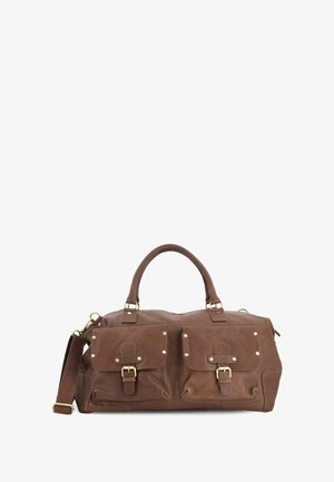 Bruine leren reistas met twee voorflapzakken die zijn beveiligd met gespen en een afneembare schouderriem op een witte achtergrond.