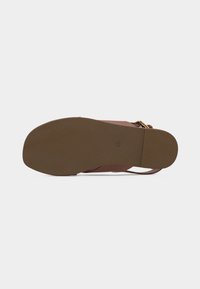 Επίπεδο καφέ πέλμα σανδάλου με την επιφάνεια προς τα επάνω που δείχνει το μέγεθος 37 και λεπτές λουρίδες με χρυσή αγκράφα σε λευκό φόντο.