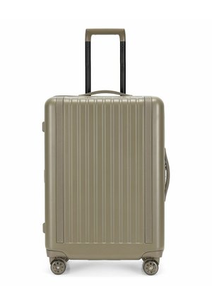 Hartschalenkoffer in Beige mit vertikalen Rillen, vier Rollen, ausgezogenem Teleskopgriff sowie seitlichen und oberen Tragegriffen.