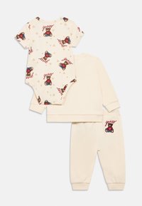 Krém színű babaruha, rövid ujjú, mackó mintás bodyval, melegítőnadrággal és a hímzett díszítésű, hozzá illő felsővel.