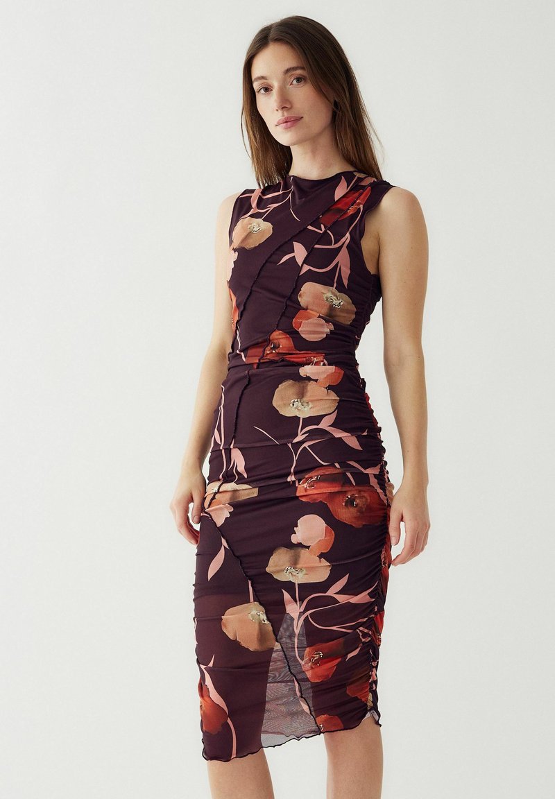 Sukienka bez rękawów, obcisła, wykonana z elastycznej, ciemnej tkaniny z różowymi i pomarańczowymi kwiatowymi wzorami. Zgromadzone detale po bokach oraz asymetryczny dół.