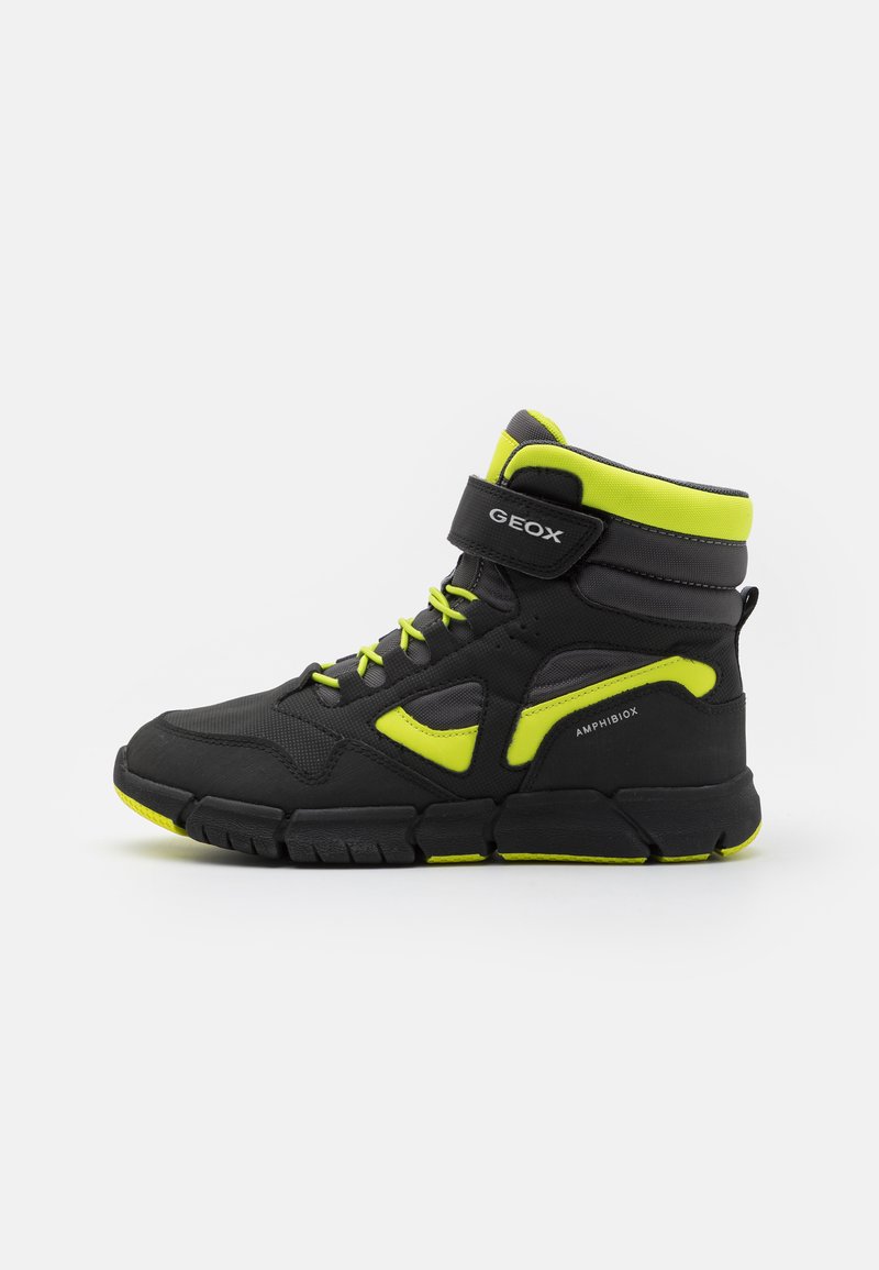 Schwarze High-Top-Sneaker mit neon-gelben Akzenten; synthetisches Material, Netzgewebe-Paneele, gepolsterter Kragen, Klettverschluss und strukturierte Gummisohle.