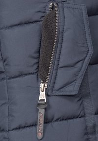 Marinblå vadderad jacka med en sidofick zip. Har en metallisk dragkedja, fleecefoder och textilier med quiltade sektioner.