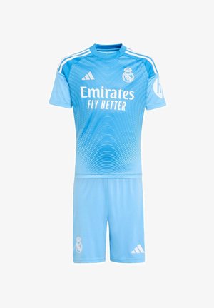 Tenue de football bleu clair du Real Madrid avec des bandes Adidas, le logo Emirates Fly Better, et le blason du club sur le maillot et le short.