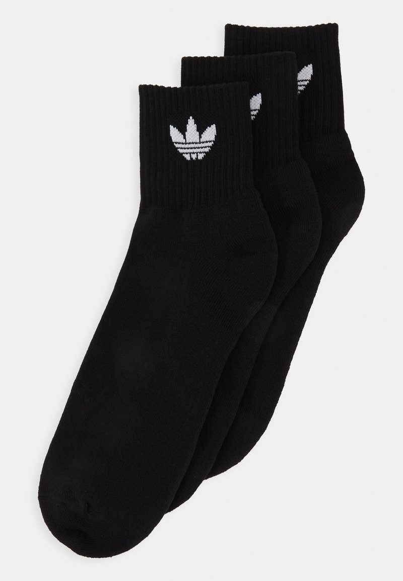 Črne bombažne nogavice do gleženj, rebraste teksture, z belim adidas trefoil logotipom na manšeti. Set treh parov.