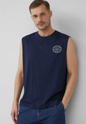 Navyblaue ärmellose T-Shirt aus Baumwolle, mit Rundhalsausschnitt und einem runden weißen Logo auf der Brust. Glatte Textur.