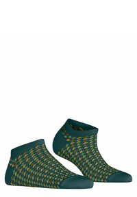 Chaussettes vertes jusqu'à la cheville avec un motif géométrique en moutarde, orange et marron. Tissu lisse avec des sections renforcées au niveau des orteils et du talon.