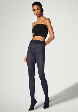 Collant a rete blu navy con una cintura alta, abbinati a un top nero senza spalline, mostrati con tacchi alti su uno sfondo a gradiente chiaro.