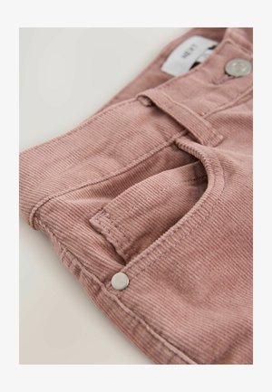 Pink corduroy trousers with a textured finish, featuring a front pocket and a metallic button. The fabric is soft with fine vertical ridges.