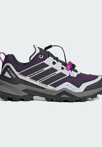 Lila und schwarze Wanderschuhe mit einem Obermaterial aus Mesh-Gewebe, Gummisohle, Schnürsystem und GORE-TEX-Label. Verfügt über ein markantes Design mit drei Streifen.
