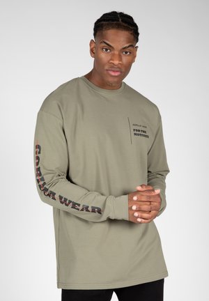 Olijfgroene lange mouwen shirt met zwart en rode tekst, met een zakprint en 'GORILLA WEAR' accent op de mouw. Soepele stoftextuur.