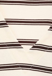 Cremfarbener Strickstoff mit dunkelbraunen horizontalen Streifen und einem V-Ausschnitt.