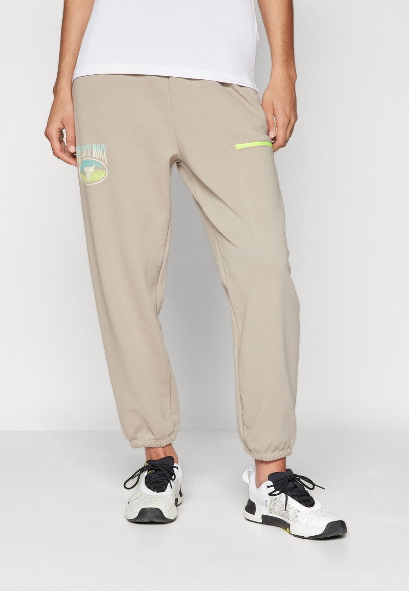 Helle beigen Sweatpants mit elastischen Bündchen, versehen mit einem blauen und grünen Grafikdesign auf dem Oberschenkel und einem neongrünen Reißverschlusstaschen-Detail.