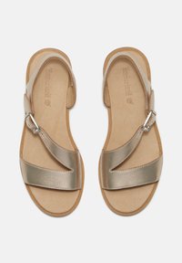 Guldmetalliska sandaler med breda korsade remmar, justerbart silverfärgat spänne och en beige vadderad sula. Platt sula med texturerade kanter.