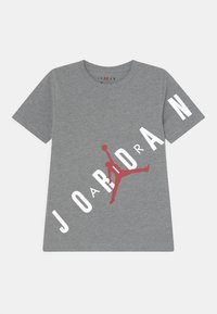Szara bawełniana koszulka z dużym czerwonym logo Jumpman oraz białym napisem "JORDAN" wydrukowanym na przodzie i rękawie. Krótkie rękawy, okrągły dekolt.