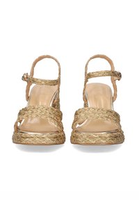Sandalias de cuña con tiras, con una textura trenzada dorada, plataforma transparente, punta abierta y correa de tobillo con una hebilla de metal. Plantilla suave color beige.