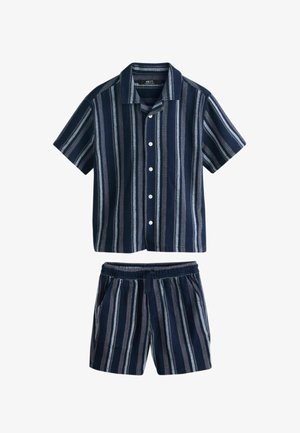 Ensemble chemise à manches courtes bleu marine avec boutons et short assorti à rayures verticales blanches et grises, taille élastique et poches latérales.