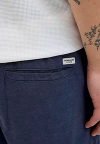 Mornarski pamučni šortsevi imaju teksturiranu bijelu gornju stranu. Šortsevi imaju stražnji džep s etiketom na kojoj piše "JACK&JONES EST.1990."