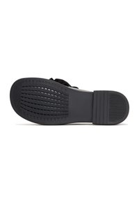 Black rubber shoe sole with textured grip, featuring a pattern of horizontal and vertical lines. Smooth edges and a flat design.