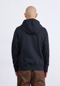 Juoda medvilninė gobtuvinė pranešėja, su kengūros kišene ir briaunotais rankogaliais. Paprastas dizainas su laisvu pjūviu. Tinka kasdieniam dėvėjimui.