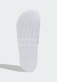 White rubber shoe sole with a zigzag traction pattern, embossed "adidas" logo, and rounded toe edge. Smooth texture with no patterns or accents.