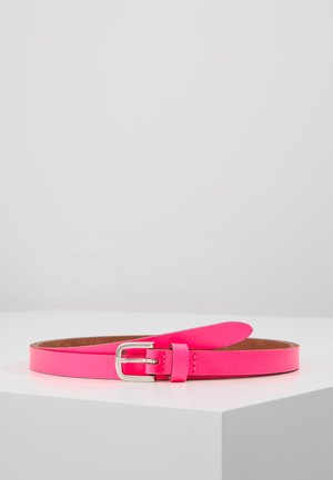 Ceinture en cuir rose vif avec boucle rectangulaire argentée reposant sur une surface blanche sur un fond gris clair uni.
