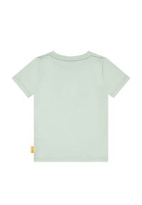 Camiseta de algodón verde claro con mangas cortas, cuello plano y una etiqueta amarilla en el costado. Textura suave, diseño minimalista y color sólido.