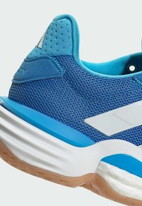 Modrá sportovní bota s prodyšným svrškem, bílými akcenty, polstrovanou podešví a texturovanou patou s perforovaným detailem.