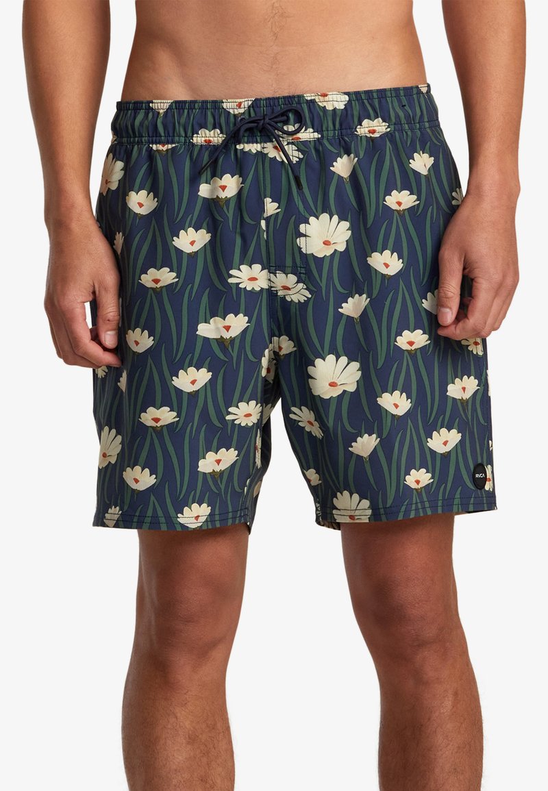 Bañador en azul marino con un patrón floral que presenta flores blancas y hojas verdes. Cintura ajustable y forro interior de malla.