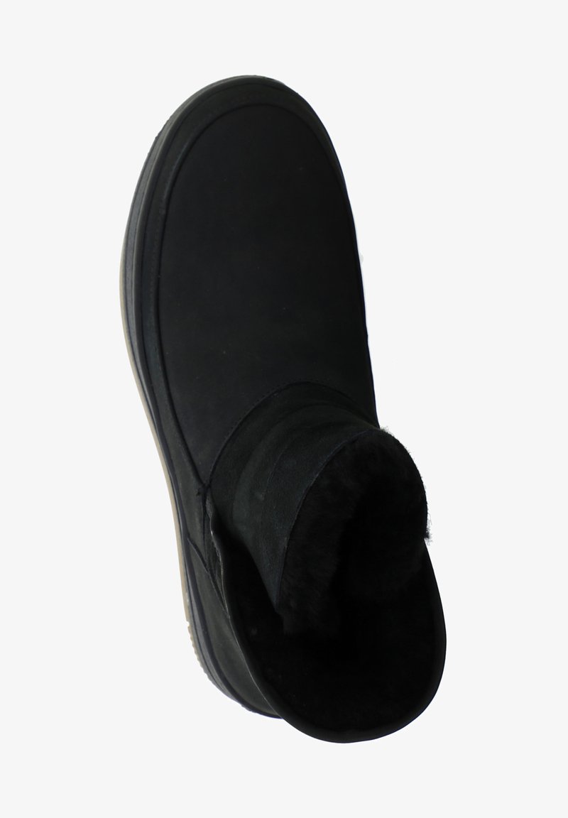 Black ankle boot made of soft suede, featuring a foldable cuff lined with fur. Rounded toe and rubber sole for traction.