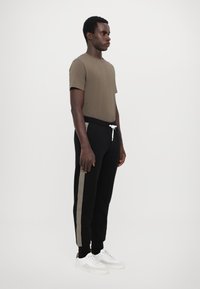 EA7 Emporio Armani PANTALONI - Treniņtērpa apakšdaļas - black