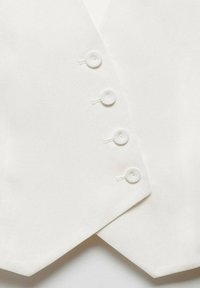 Gilet bianco con un collo a V affilato, quattro bottoni rotondi e una texture liscia. Ha un design su misura e linee pulite.