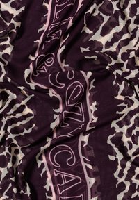 Sciarpa con stampa animale viola e beige, in tessuto leggero, caratterizzata da un bordo rosa brillante con testo geometrico. Morbido al tatto con un drappeggio fluente.