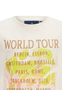 Cremefarbenes T-Shirt mit Rundhalsausschnitt, auf dem der Text "WORLD TOUR" in Gold steht, umgeben von einem bunten geografischen Muster in Grün und Pink.