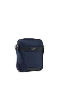 Sac à bandoulière en nylon marine avec un panneau avant en cuir noir texturé, quincaillerie en argent et une bandoulière réglable avec un logo en relief.