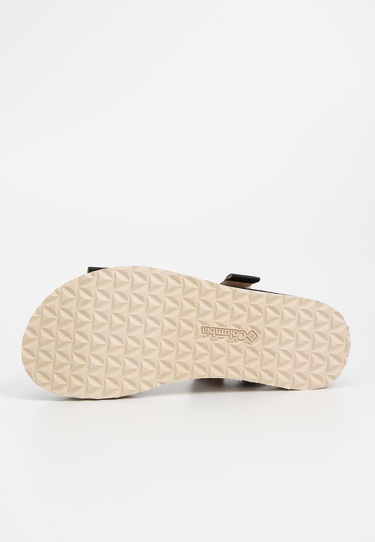 Sandale marron clair avec une semelle en caoutchouc texturé, ornée d'un motif géométrique. Sangles ajustables et tissu doux pour le confort.