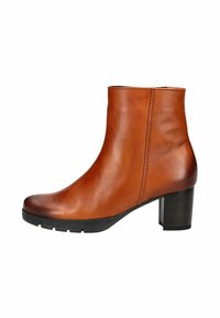 Bottine en cuir marron avec un bout arrondi, fermeture éclair sur le côté et un talon bloc noir moyen. Texture lisse avec des détails de couture minimaux.