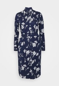 Mörkblå långärmad klänning med blommönster i vitt, knäppt fram, krage och bälte i midjan, tillverkad av ett tyg med en mjuk textur.