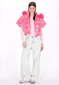 Rózsaszín steppelt dzseki fényes felülettel és lekerekített vállakkal, világos rózsaszín hosszú ujjú felsővel és bő szárú világoskék farmerral párosítva. Ezüst cipők.