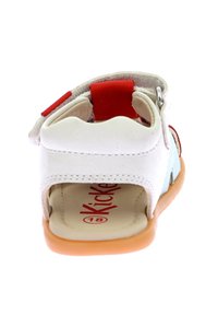 Sandale en cuir blanc avec des accents rouges et un talon arrondi. Design à dos ouvert, semelle légère et logo sur la semelle intérieure. Taille 18.