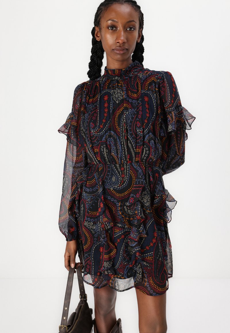 Vestido oscuro con estampado de paisley, con mangas rizadas y un escote alto. Hecho de tejido transparente con intrincados acentos de color.