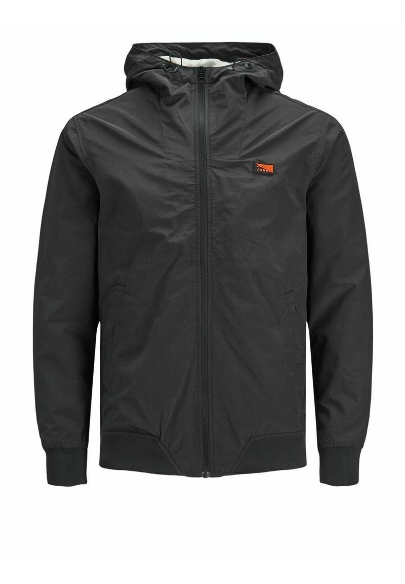 Giacca leggera nera con cappuccio, zip frontale, polsini elasticizzati e un piccolo logo arancione sul lato sinistro del petto. Tessuto liscio e resistente all'acqua.