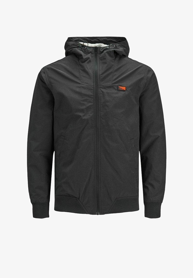 Giacca leggera nera con cappuccio, zip frontale, polsini elasticizzati e un piccolo logo arancione sul lato sinistro del petto. Tessuto liscio e resistente all'acqua.