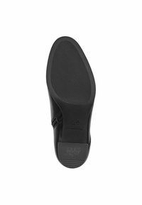 Suela de zapato negra con patrón de agarre texturizado y forma redondeada. El lateral muestra un cierre de cremallera. Nombre de la marca "Tommy Hilfiger" visible en la suela.
