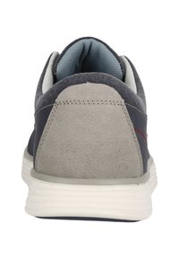 Sko med en gråmocka häl, marinblå mesh-övre del, vit gummisula och röd sömnad. Texturerad och strukturerad för stöd.