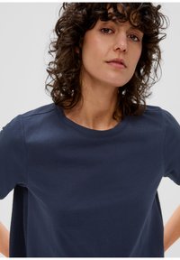 Granatowa koszulka z krótkim rękawem w miękkim materiale, z okrągłym dekoltem i bocznym panelem, charakteryzująca się luźnym krojem i gładką teksturą.