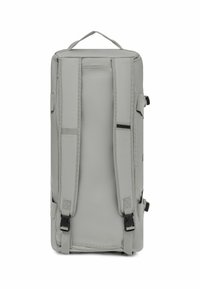 Sac à dos en tissu gris durable avec des bretelles réglables, des coutures renforcées et une poignée supérieure. Il comprend des boucles de compression latérales et un design élégant.