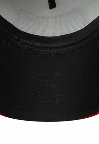 Schwarze Kappe mit einer glatten, strukturierten Oberfläche, versehen mit einem grauen Innenfutter und einem roten Akzent an der Unterseite des Schirms.